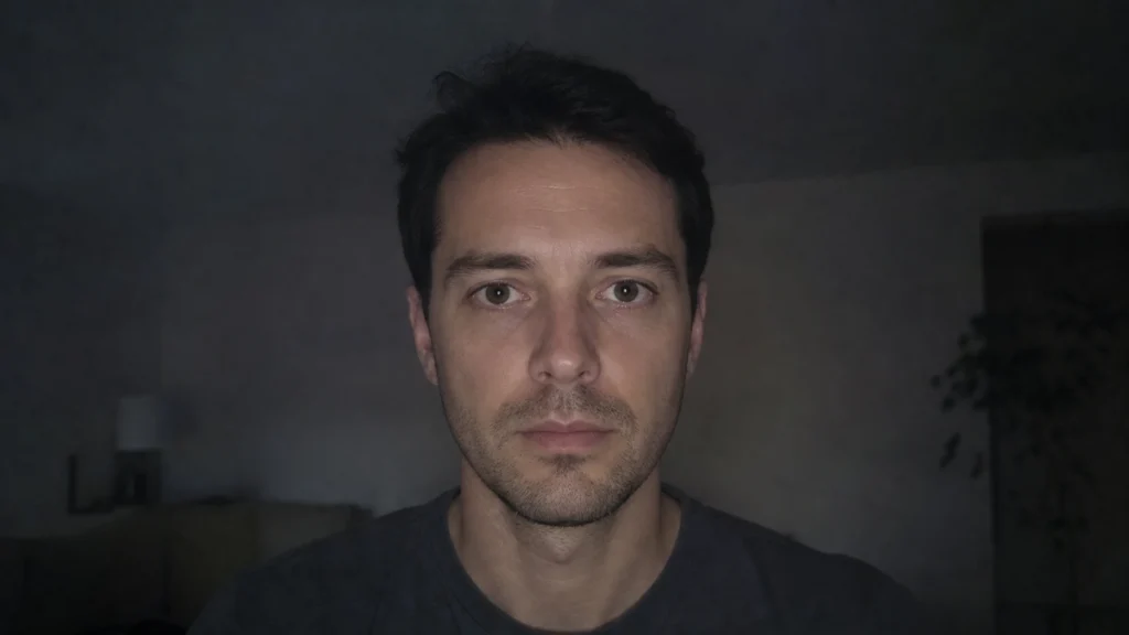 Portrait d’un homme dans une pièce tamisée, les yeux adaptés à la faible luminosité
